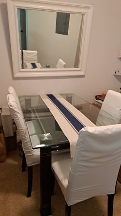 glass dining table with 4 white chairs