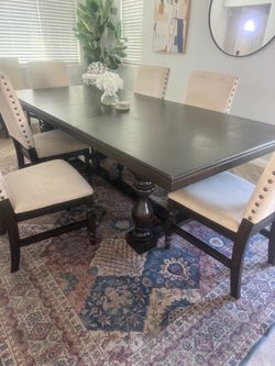 Black wood dining table plus cream fabric chairs