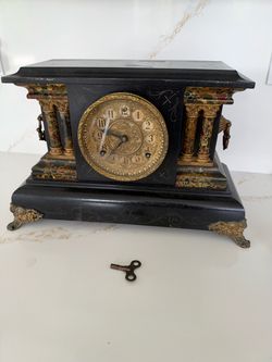 Antique French-style mantel clock with a black slate and marble case