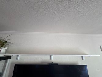 3 Wall mounted white shelves with brackets.