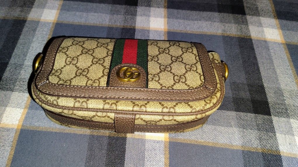 Gucci Ophidia mini bag in beige and ebony GG Supreme canvas with brown leather trim and gold-toned hardware.