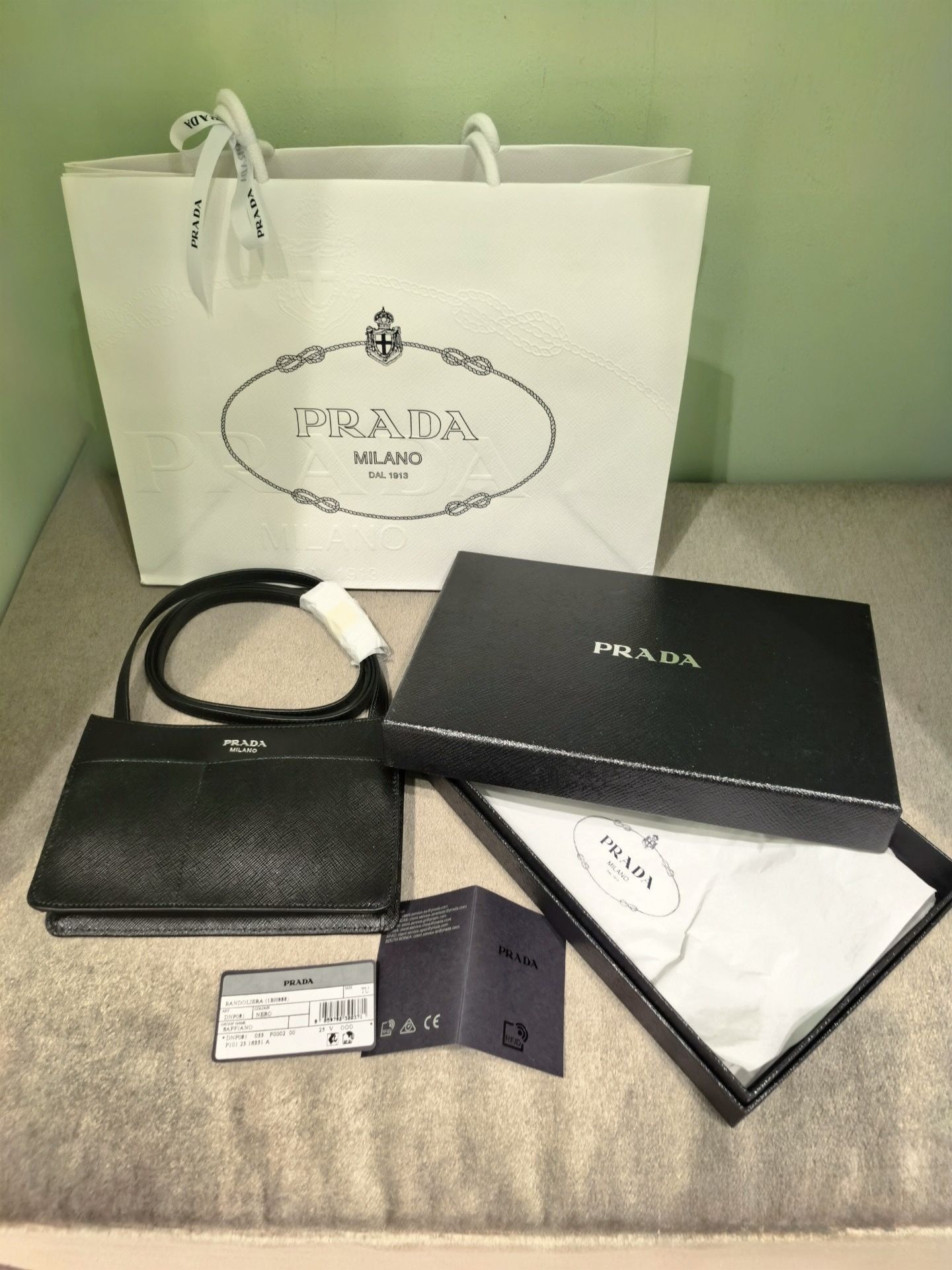 100% Authentic PRADA Saffiano Leather Crossbody Phone Bag – Nero (Black) Silver-Tone Item Details: • Brand: PRADA • Style: Flat Crossbody / Cellpho