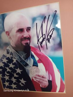 framed, autographed photograph of legendary American tennis player Andre Agassi holding his gold medal draped in an American flag after winning the si