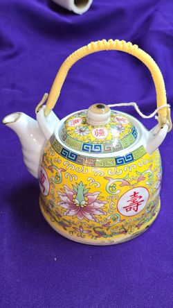 Vintage Chinese Porcelain Teapot featuring a yellow background and a woven plastic handle. A67V005