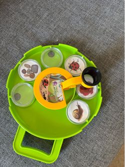 green plastic Fun Maker field microscope features a rotating tray with six individual observation containers to safely view insects, rocks, and