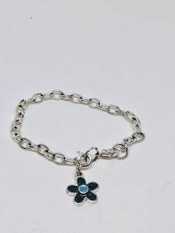 Silver tone bracelet with enameled flower charm in black and blue