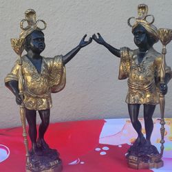 Pairs blackamoor candlesticks, late 19th/ early 20th C., each featuring a figure of a baby-faced, dark skinned