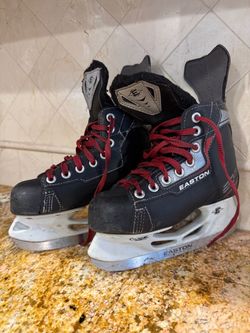 Pair of black and red Easton Synergy EQ ice hockey skates featuring white holders and red laces. Size 1