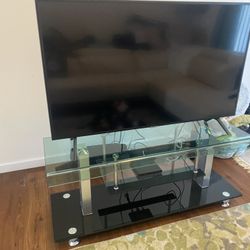 Flat Screen TV + Glass TV Stand (Modern Setup – Ready to Go)