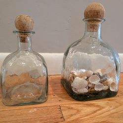 Two glass Patrón Tequila bottles with cork stoppers
