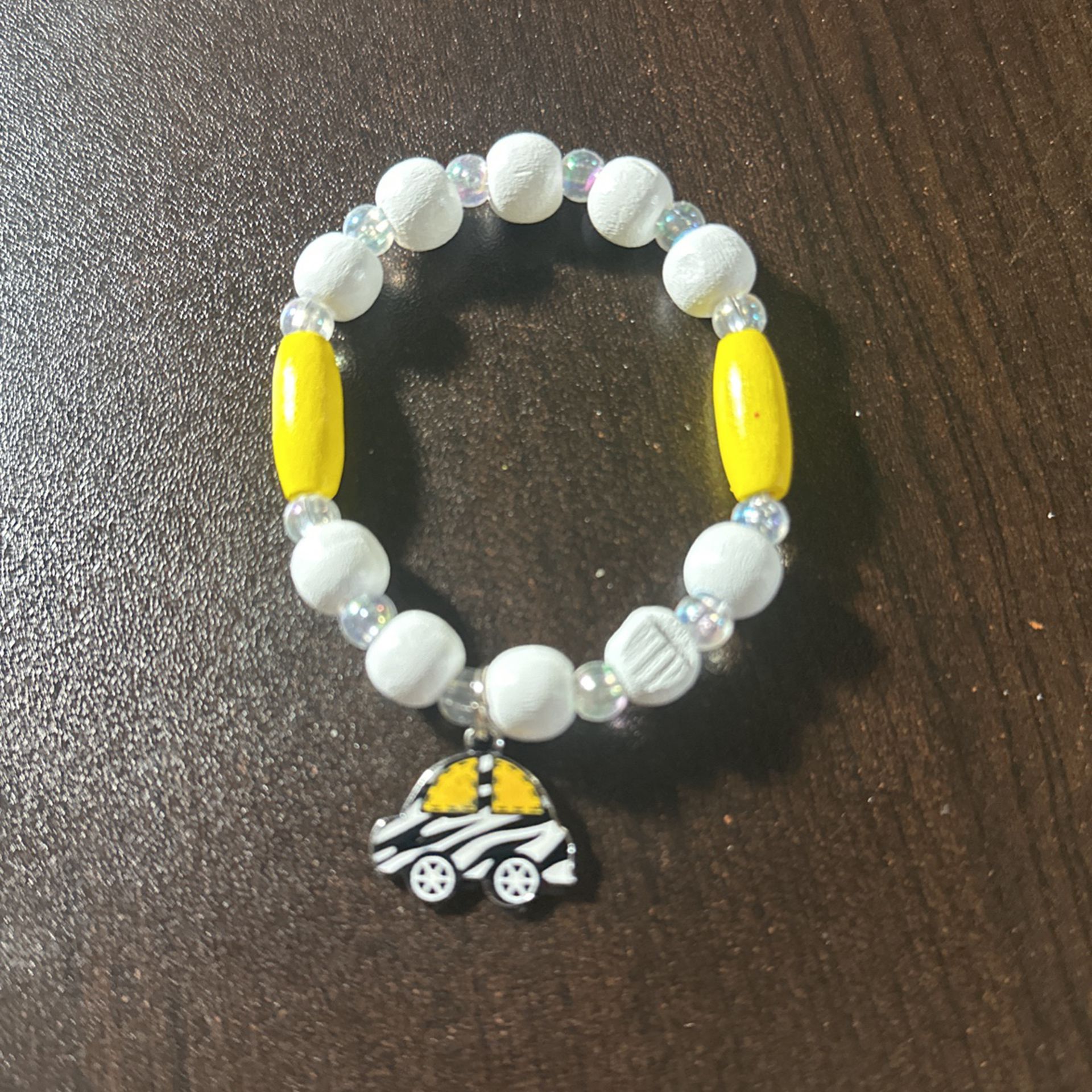 White, Yellow, And Clear Beads Bracelet With A Black White And Yellow Car Charm