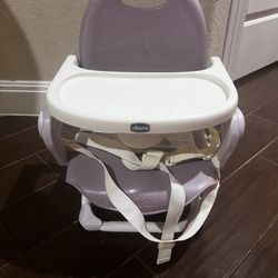 Chicco booster seat in good used condition with removable tray and adjustable safety straps. 