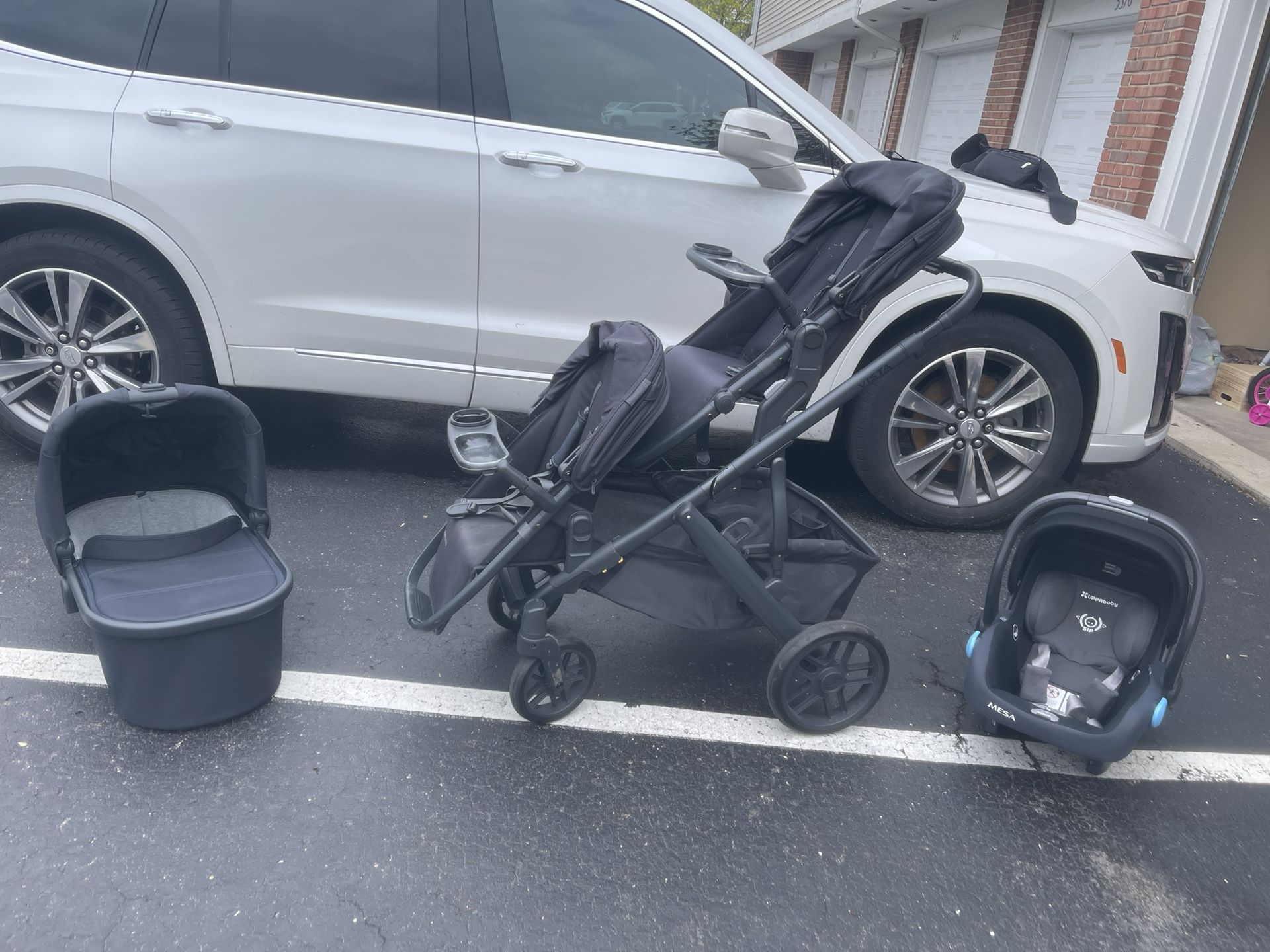 3 pieces Uppa baby double stroller with car seat, bassinet, snack trays, and adapters.