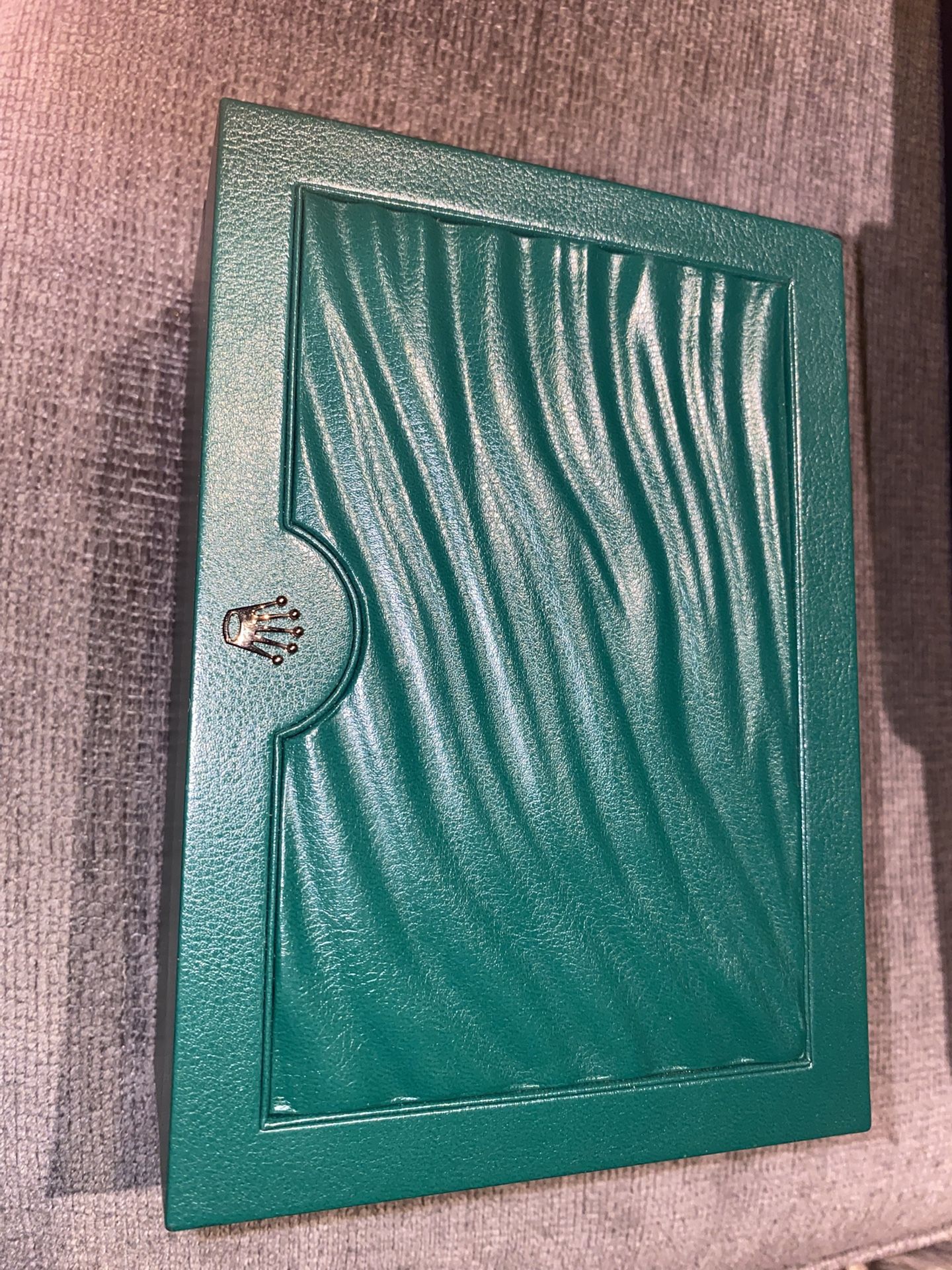 Rolex watch presentation box in green with an ivory interior.