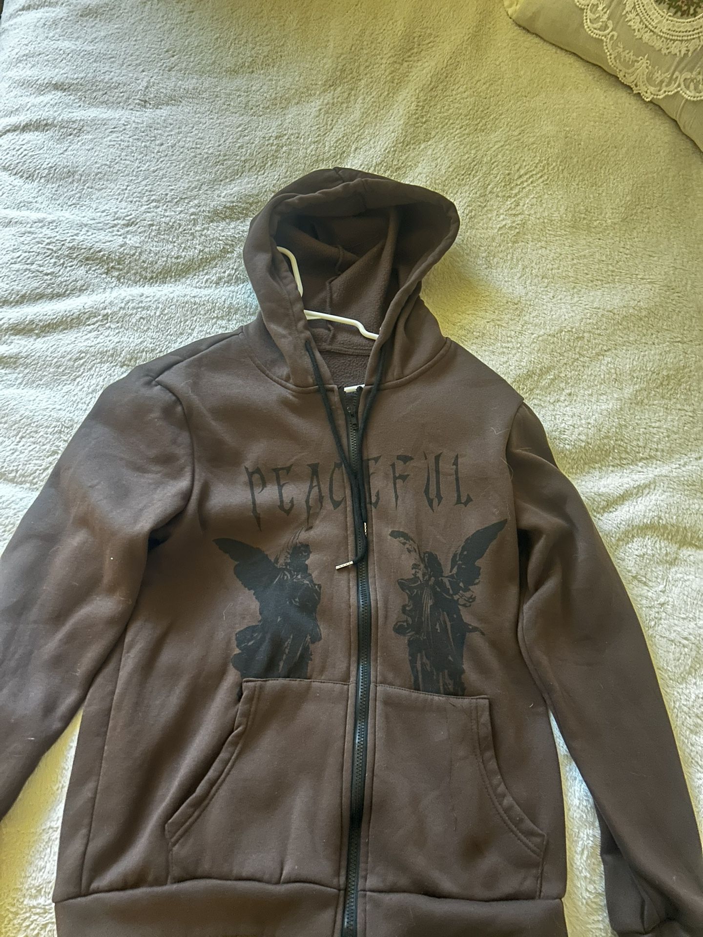 Brown hoodie with angel designs and peaceful text