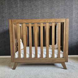 DaVinci Otto 3-in-1 Convertible Mini Crib with a 4" mattress. 