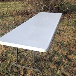 8 ft long x 3 ft Rubbermaid plastic table with folding legs