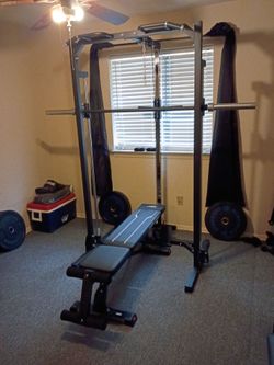Smith machine with plates, bench, punching bag, boxing gloves, and treadmill