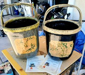 two large glazed ceramic bucket planters featuring arched cane or bamboo-wrapped handles