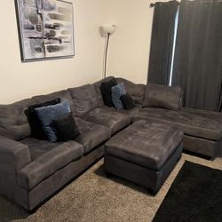 Grey Couch With Ottoman and Pillows