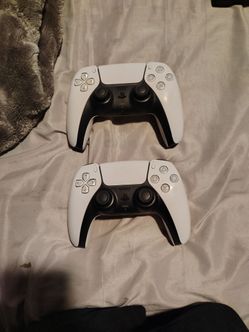 2 Ps5 controllers and a dual controller charging dock