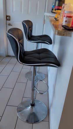 modern adjustable bar stools with chrome bases and black faux leather seats. Chair