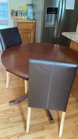 A round wood table with vinyl 4 leather chairs  - make an offer