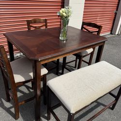 Wooden high table and 3 chairs and a bench