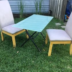 A Glass Table (44” Long  X 24” Wide ) with  Two Nice Chairs  That Need Some Cleaning 