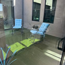 Two Metal Rocking Chairs With Blue Cushions