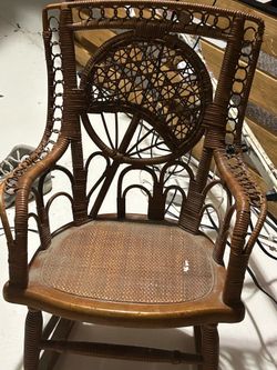 This is an antique Victorian-style child's wicker rocking chair from the late 19th or early 20th century