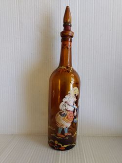 Hand-painted vintage glass bottle featuring folk-art figures with woode stopper