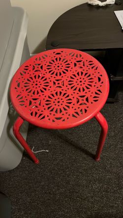 This red urb SPACE Daisy stackable metal stool features a intricate floral design on the seat