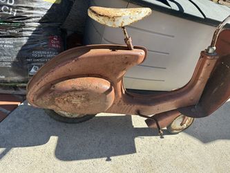 Classic old red steel aerodynamic scooter. Chain and drive train complete and working