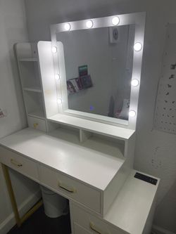 White & gold vanity with mirror Tocador blanco y dorado con espejo.