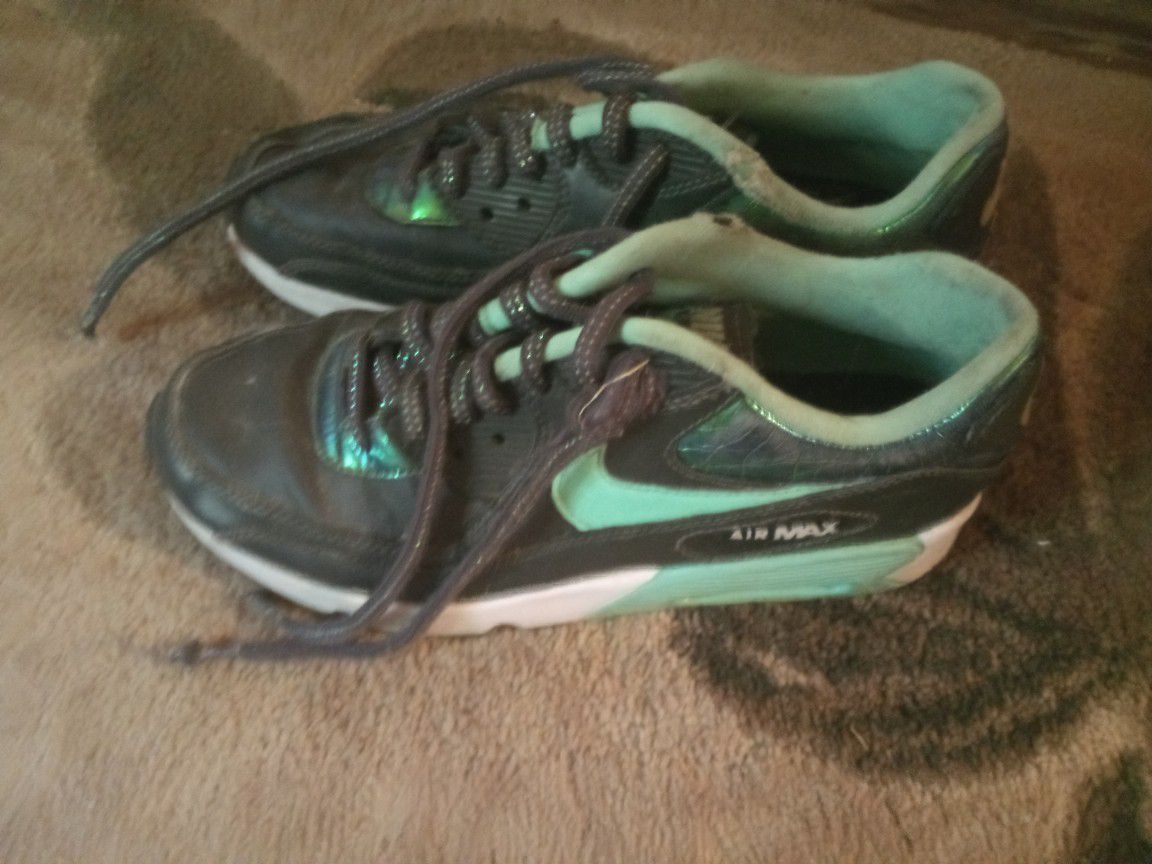 Pair of black and green Nike AirMax Shoes