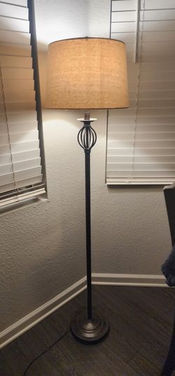 Bronze Finish Spindle Floor Lamp with Oatmeal Fabric Drum Shade, 60"Stylish floor lamp. Dark metal base and stand has a cool cage design. Fabric shade