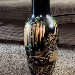 black, possibly vintage, Chinese or Japanese vase with gold and green accents depicting a landscape scene