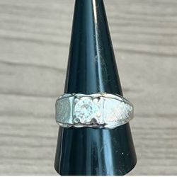 Elegant sterling silver-stamped ring with a single clear center stone. Designed for everyday wear with a polished finish. The silver color adds versa