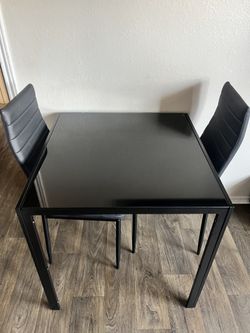 Black glass dining table great conditions Includes 2 chairs great conditions delivery available