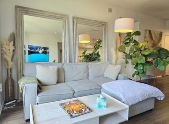Light gray sectional sofa with (1) pull out bed and (2) storage compartment in chaise lounge