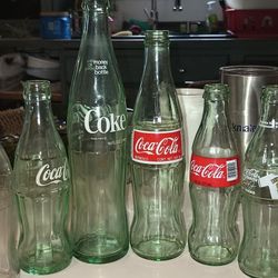 Vintage Coca Cola Lot 6 Glass Bottles..1)Rare Clear 10 Oz 70s. 2) 6.5 Oz Heavy Green 70s. 3) 11.25 Inch Tall Green 70s4) 355ml Mexico Green Red Label 