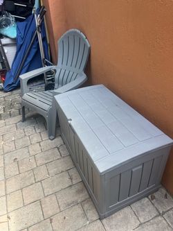grey, vertical-slatted resin outdoor storage deck box, resembling a Suncast 50-Gallon Plastic Deck Box.