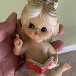 Vintage girl reading a book and an angel blowing kiss