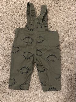 Cute olive green overalls with an allover dinosaur print. Soft, durable fabric made for everyday play. Easy snap closures for quick changes. Classic u