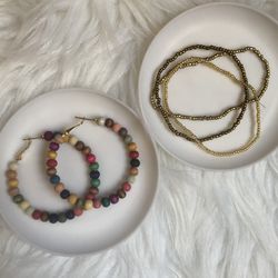 Colorful beaded hoop earrings and three gold beaded bracelets