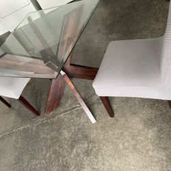 glass table with chairs with covers 