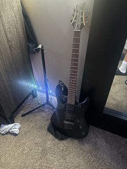 Eletric gutiar with stand and strap missing a string