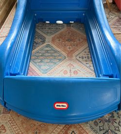 Little Tikes blue race car Toddler bed frame.   Mattress and metal insert or wood slats to support the mattress properly are not included.