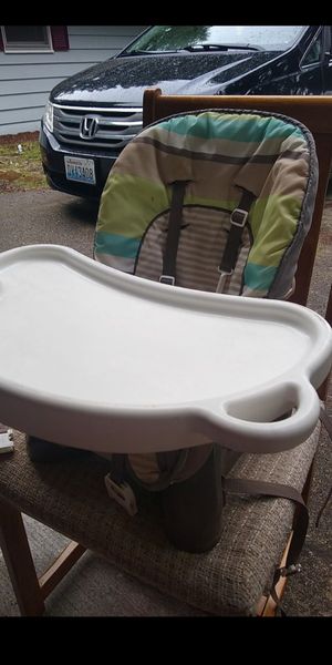 Photo Fisher Price high chair booster seat. This booster seat straps to a kitchen chair.